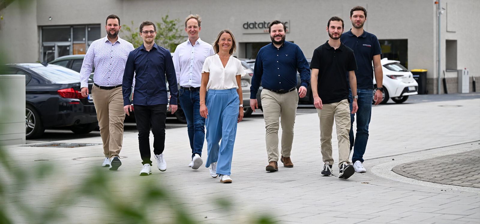Mehrere Menschen umarmen sich fröhlich im Kreis.